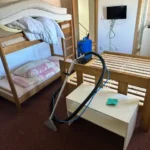 Úklid pokoje s postelemi a vysavačem
